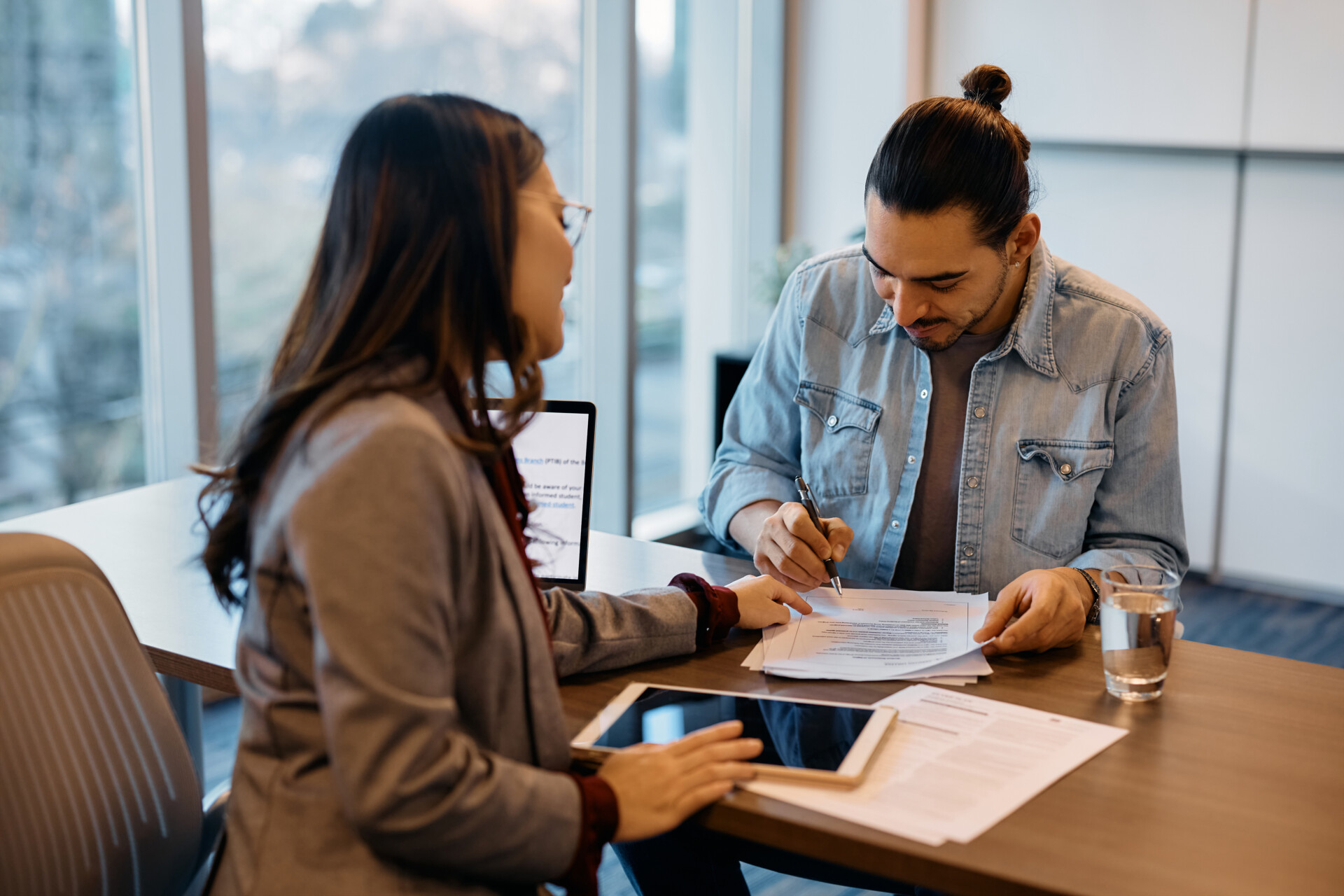 Ragazzo con consulente finanziaria durante una consulenza per prestito personale